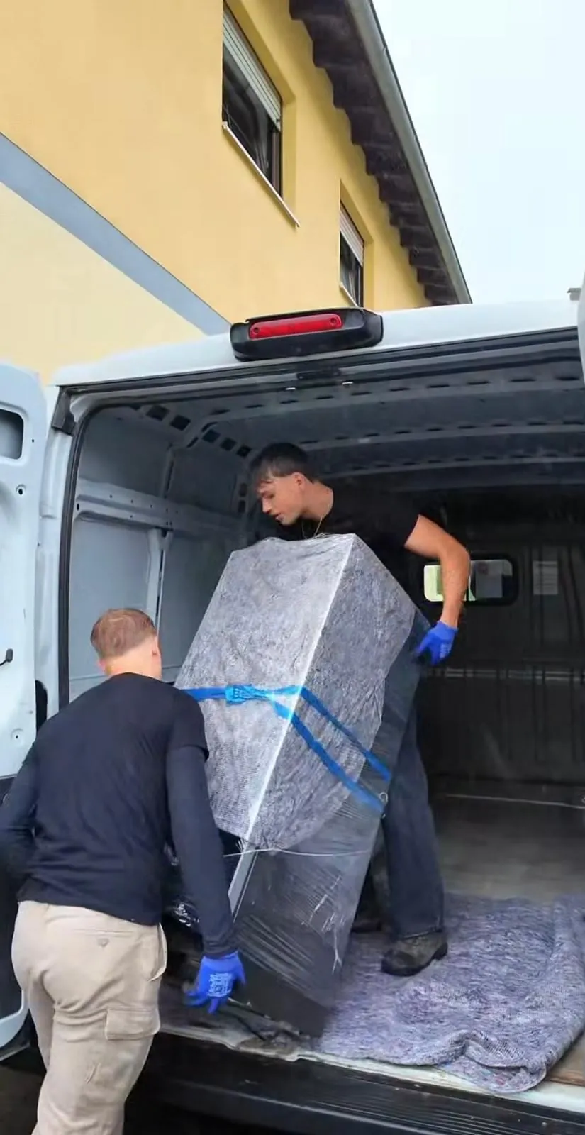 Ein verpacktes Gerät wird in den Transporter geladen